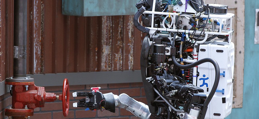 Robot Running Man from the Florida Institute for Human and Machine Cognition proceeds to turn a valve in the next stage of the competition during the DARPA Robotics Challenge.