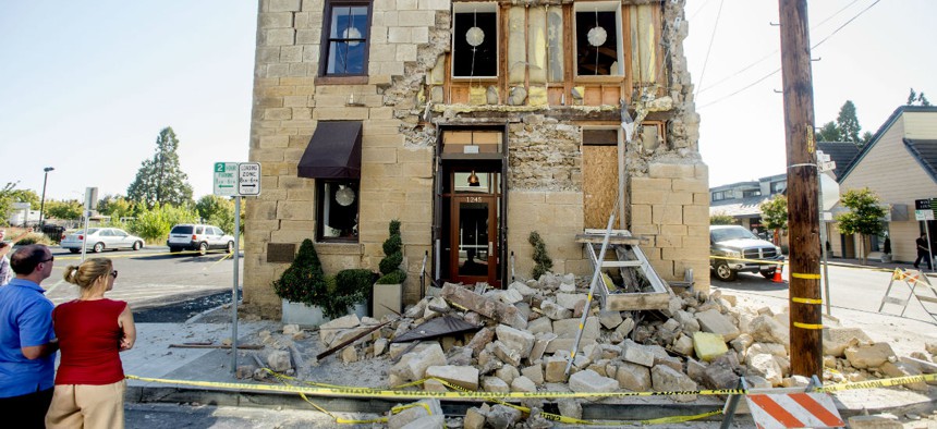 Pedestrians examine a crumbling facade following an earthquake in Napa, California.