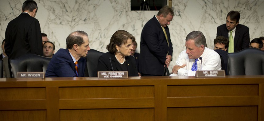 Senate Intelligence Committee Chairman Sen. Richard Burr, R-N.C., right, confers with committee Vice-Chair. Sen. Dianne Feinstein, D-Calif., center, and committee member Sen. Ron Wyden, D-Ore., on Capitol Hill.