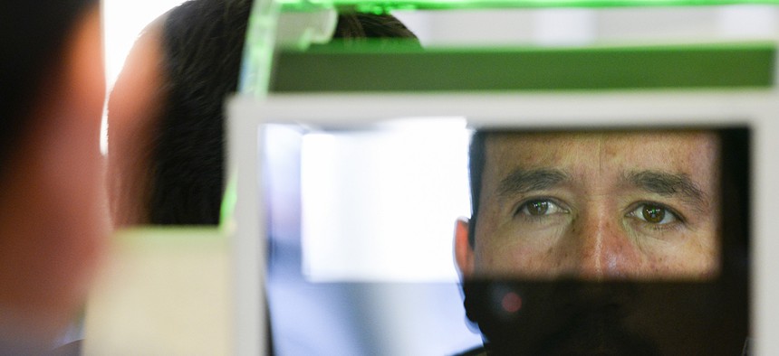 A pedestrian crossing from Mexico into the United States at the Otay Mesa Port of Entry has his facial features and eyes scanned at a biometric kiosk, Dec. 10, 2015, in San Diego.