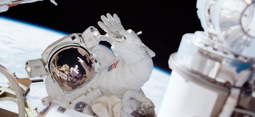 Astronaut Carlos I. Noriega, mission specialist, waves toward his partner, astronaut Joseph R. Tanner during a space walk.