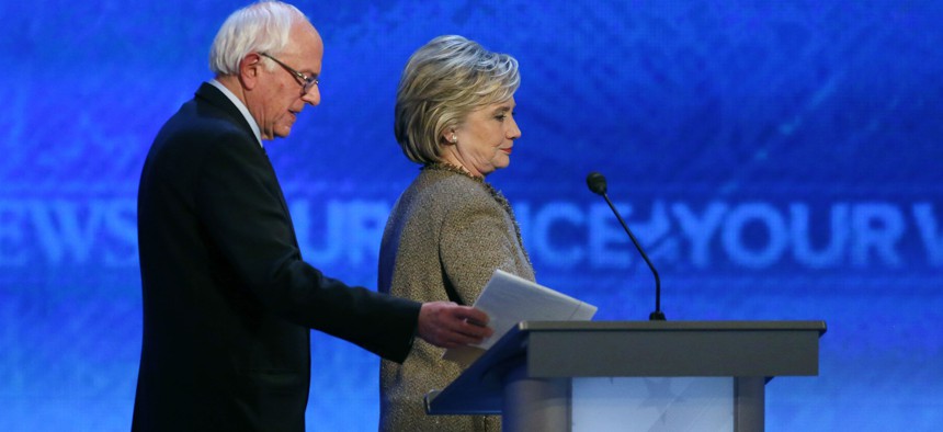 Bernie Sanders, left, and Hillary Clinton return after a break during a Democratic presidential primary debate Saturday, Dec. 19, 2015, at Saint Anselm College in Manchester, N.H. 