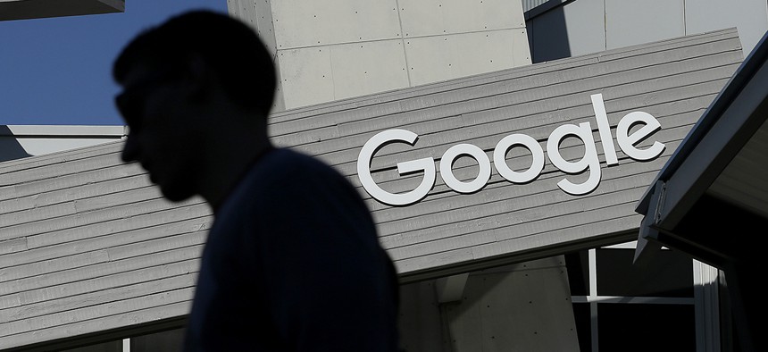 A man walks past a building on the Google campus in Mountain View, Calif.