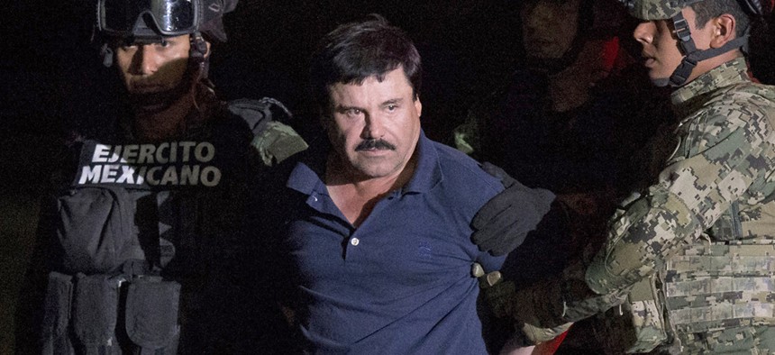 Mexican drug lord Joaquin "El Chapo" Guzman is escorted by army soldiers to a waiting helicopter, at a federal hangar in Mexico City, Friday, Jan. 8, 2016. 