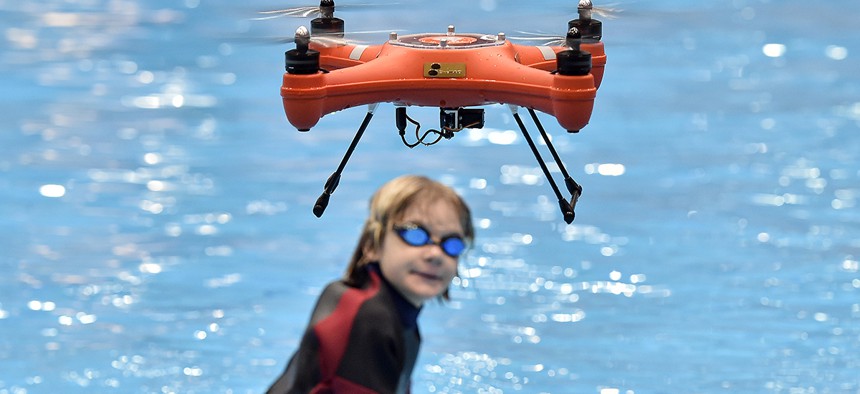 A water drone demonstrates maritime salvage by flying a lifesaver to a boy in the water, at the world's largest watersports trade fair BOOT in Duesseldorf, Germany, Friday, Jan. 22, 2016.
