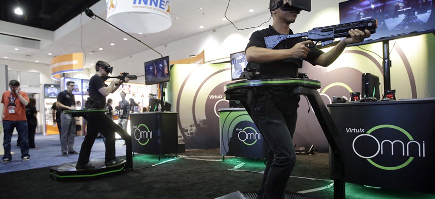 Gamers demonstrate on the Virtuix Omni virtual reality treadmills at the Electronic Entertainment Expo on Wednesday, June 11, 2014, in Los Angeles.
