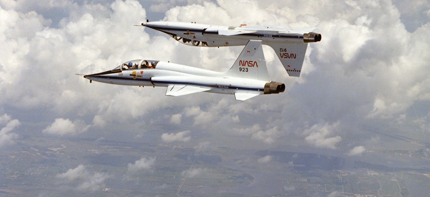 A pair of T-38s fly in formation over Galveston Beach in Texas, showing some of the aerobatic abilities of the aircraft.