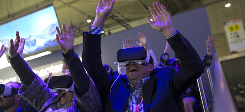 People react as they use the new Samsung Gear 360, a 360-degree camera, during the Mobile World Congress Wireless show in Barcelona, Spain, Wednesday, Feb. 24, 2016.