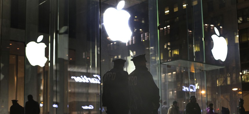 New York police officers stand outside the Apple Store on Fifth Avenue while monitoring a demonstration, Tuesday, Feb. 23, 2016.