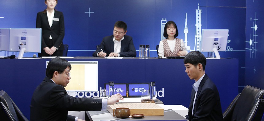 Professional Go player Lee Sedol, right, watches as Google DeepMind's lead programmer Aja Huang, left, puts the Google's artificial intelligence program, AlphaGo's first stone during the final match of the Google DeepMind Challenge Match.