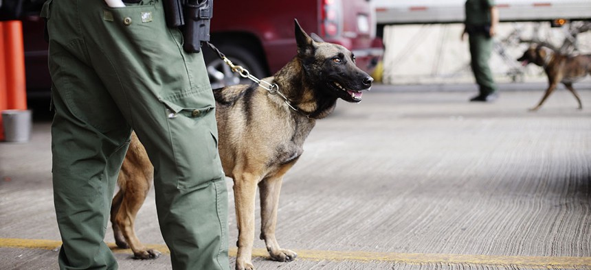 U.S. Customs and Border Patrol agents and K-9 security dogs keep watch at a checkpoint station, on Feb. 22, 2013, in Falfurrias, Texas.