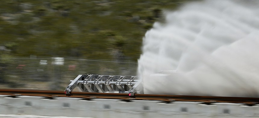 A sled speeds down a track during a test of a Hyperloop One propulsion system, Wednesday, May 11, 2016, in North Las Vegas, Nev.