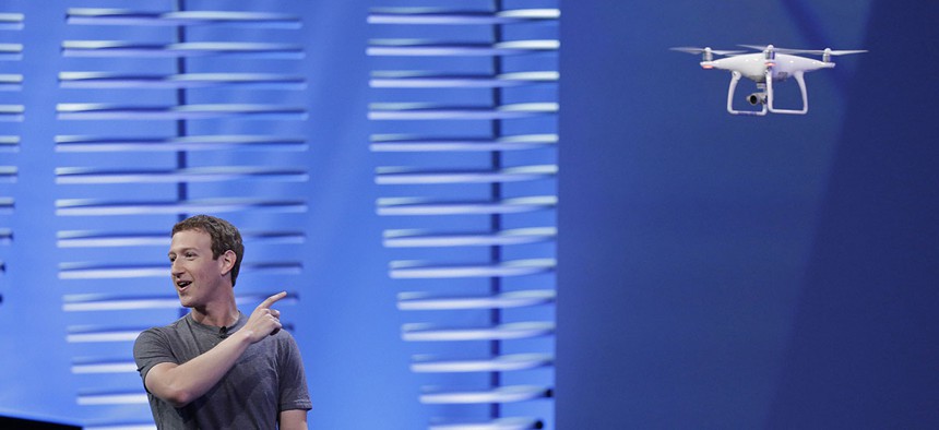 Facebook CEO Mark Zuckerberg points to a drone flying behind him during his keynote address at the F8 Facebook Developer Conference Tuesday, April 12, 2016