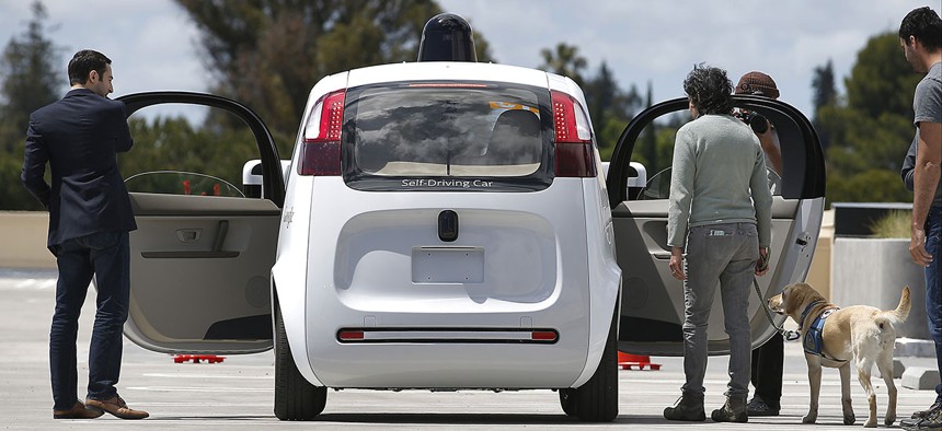 Riders enter the Google's new self-driving prototype car for a ride during a demonstration at Google campus on Wednesday, May 13, 2015.
