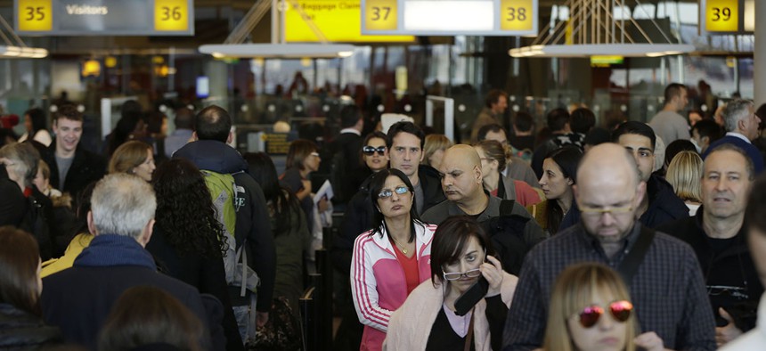 Travelers wait in a winding line to pass through customs and border control at John F. Kennedy Airport in New York.