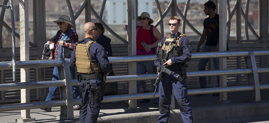 Pedestrians cross into Juarez, Mexico as U.S. Customs and Border Protection officers of the Special Response Team unit, patrol the Paso del Norte Port of Entry in El Paso, TX.