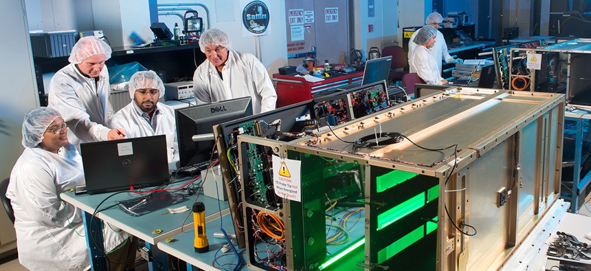 A team of scientists and engineers test the components of Saffire I (background) and Saffire II (foreground)