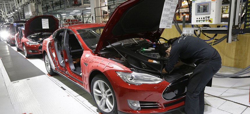 Tesla employees work on a Model S cars in the Tesla factory in Fremont, Calif.
