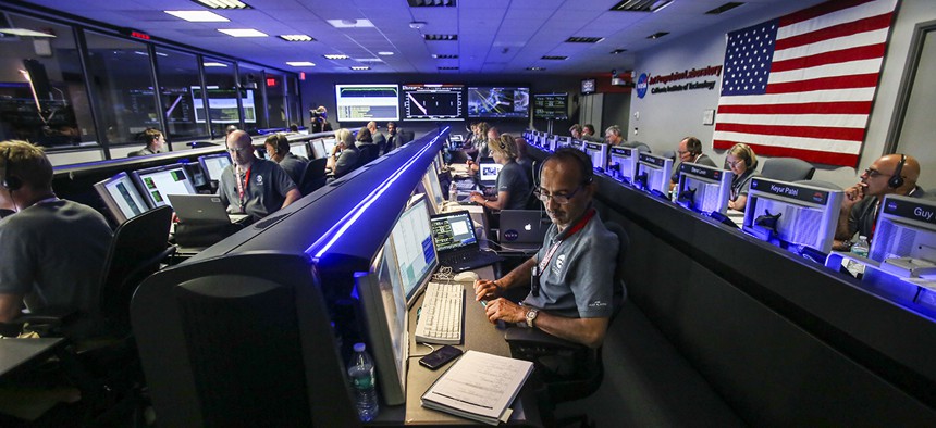 Staff members of Juno Mission watch on before the solar-powered Juno spacecraft went into orbit around Jupiter, at NASA's Jet Propulsion Laboratory in Pasadena, Calif., on July 4, 2016.