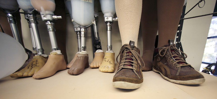 Artificial legs, which have been serviced for clients, rest on a shelf at the family-owned United Prosthetics company in the Dorchester neighborhood of Boston. 