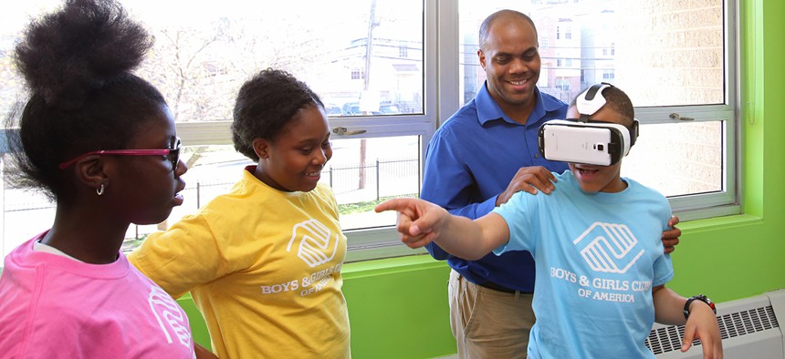 meer Washington, development associate at Boys & Girls Club of Newark assists a student with Samsung’s Gear VR to help experience virtual reality at the Boys and Girls Club of Newark.