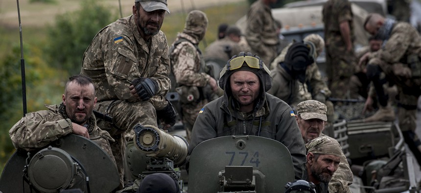 Russian-backed forces in eastern Ukraine are using rapidly innovating IT and EW tactics. Here, Ukrainian servicemen ride an armored vehicle near Krasnoarmiisk in eastern Ukraine in 2015.