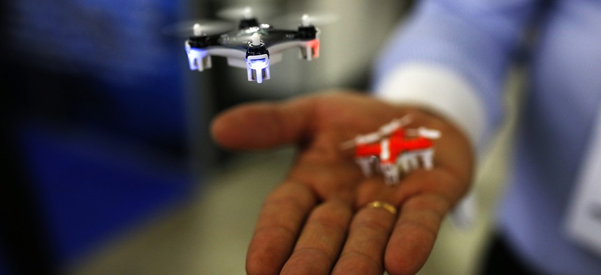 A man controls a mini drone during the Global Robot Expo fair in Madrid, Thursday, Jan. 28, 2016. 