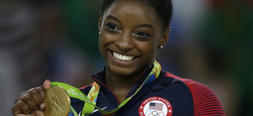 United States' Simone Biles displays her gold medal for floor during the artistic gymnastics women's apparatus final at the 2016 Summer Olympics.