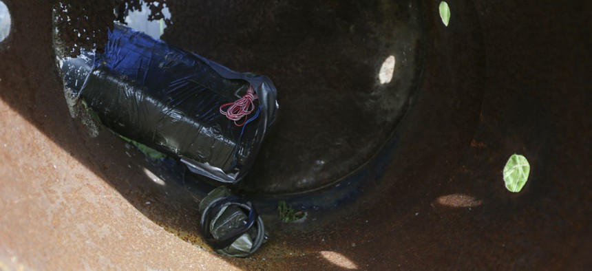 An improvised explosive device sits partially concealed in a barrel during counter-improvised explosive device skills demonstration training exercise at Camp Lejeune, N.C., Sept. 1.