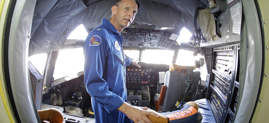 U.S. Navy Capt. Harris Halverson, shown in this ultra wide angle photo, demonstrates some of the functions in the cockpit of the National Oceanic and Atmospheric Administration's P-3 turboprop aircraft "Miss Piggy".