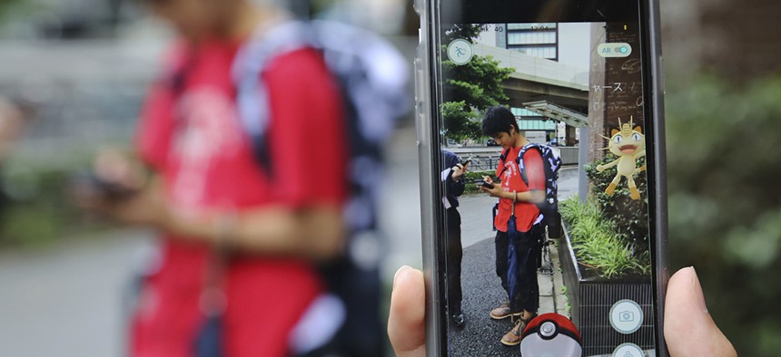 Japanese students play "Pokemon Go" in the street as its released in Tokyo. 