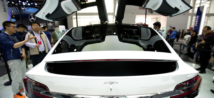 A visitor looks at a Tesla Model X on display at the Beijing International Automotive Exhibition.