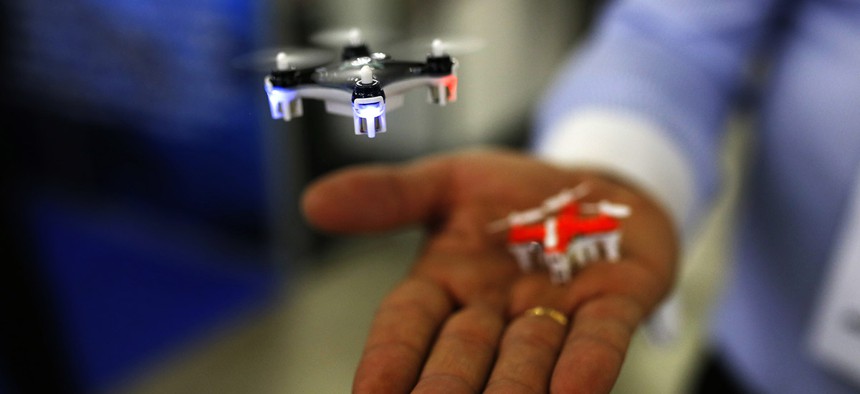 A man controls a mini drone during the Global Robot Expo fair in Madrid, Thursday, Jan. 28, 2016.