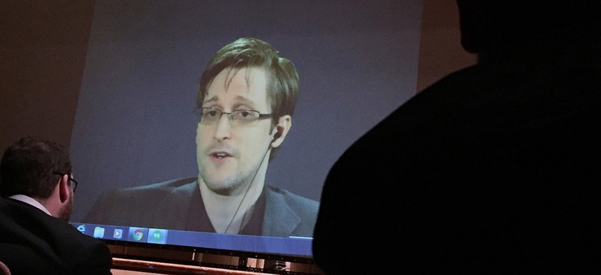 Former NSA contractor Edward Snowden, center speaks via video conference to people in the Johns Hopkins University auditorium, in Baltimore.