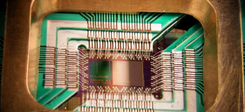A chip constructed by D-Wave Systems Inc., designed to operate as a 128-qubit superconducting adiabatic quantum optimization processor, mounted in a sample holder.