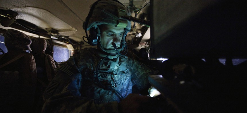 Specialist Matthew Syperda of the 3rd Brigade Combat Team, 1st Cavalry Division, looks at his cellular phone inside his unit's Mine Resistant Ambush Protected vehicle. 