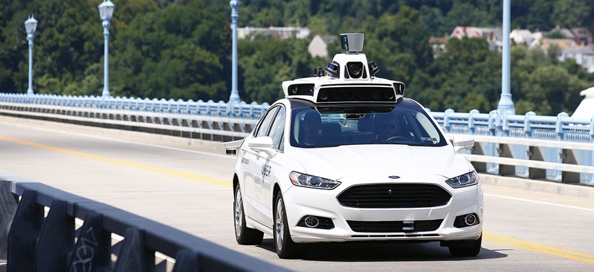 Uber employees test a self-driving Ford Fusion hybrid car, in Pittsburgh. 