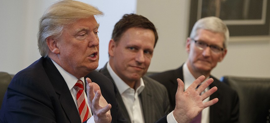 Apple CEO Tim Cook, right, and PayPal founder Peter Thiel, center, listen as President-elect Donald Trump speaks during a meeting with technology industry leaders at Trump Tower in New York, Wednesday, Dec. 14, 2016. 