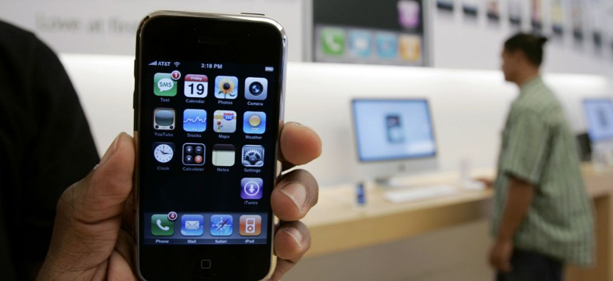 A customer holds an Apple iPhone at the Apple store in Palo Alto, Calif., Friday, Oct. 19, 2007. 