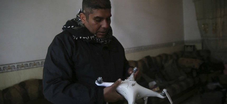 Iraqi special forces Lt. Col. Ali Hussein holds a destroyed drone used by Islamic State militants, which was shot down by his brigade, in the Bakr front line neighborhood, in Mosul, Iraq, Friday Nov. 25, 2016.