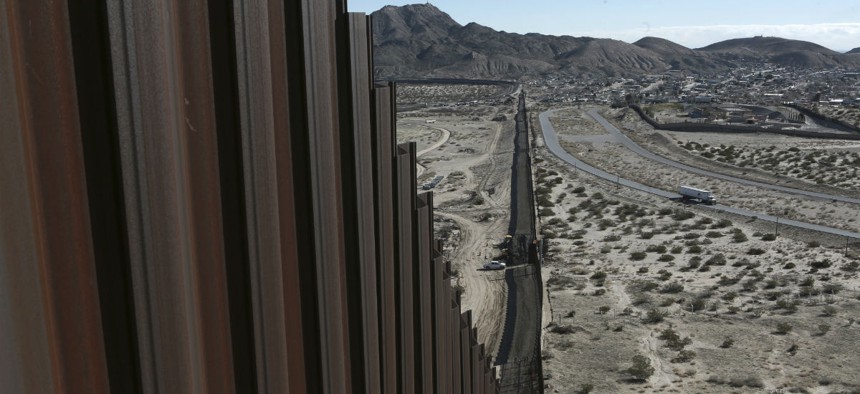 A truck drives near the Mexico-US border fence.