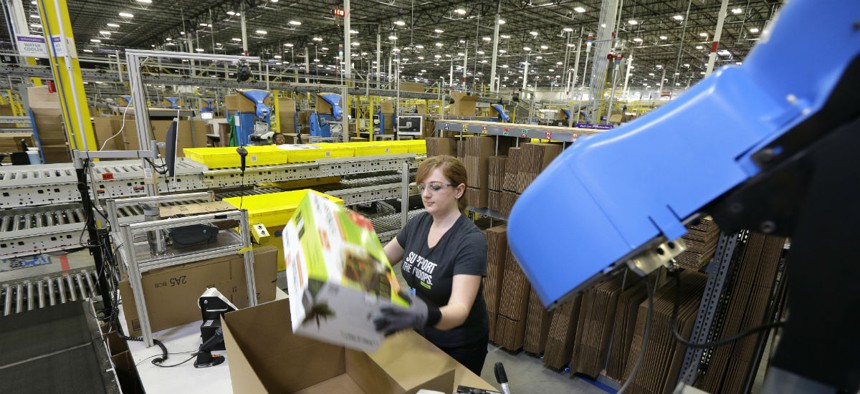 A worker places an item in a box for shipment,at a Amazon.com fulfillment center in DuPont, Wash.