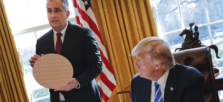 President Donald Trump looks at Intel CEO Brian Krzanich, holding a silicon wafer, during their meeting in the Oval Office of the White House in Washington, Wednesday, Feb. 8, 2017. 