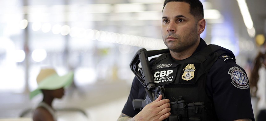 A U.S. Customs and Border Protection officer patrols outside of the departures area at Miami International Airport, Friday, July 1, 2016.