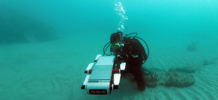  Yogesh Girdhar, a researcher at Woods Hole Oceanographic Institute, swims with a "curious" robot he helped build.