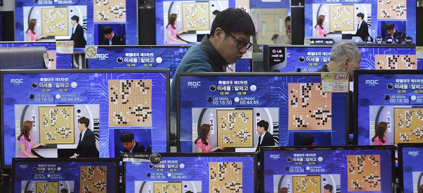TV screens show the live broadcast of the Google DeepMind Challenge 