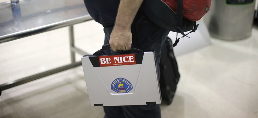 A passenger takes out a laptop with a sticker on it while entering a security checkpoint at Hartsfield-Jackson Atlanta International Airport Thursday, Nov. 18, 2010 in Atlanta.