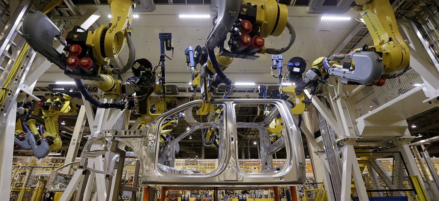 Robots fasten parts on a new 2015 aluminum-alloy body Ford F-150 truck in the body shop at the company's Kansas City Assembly Plant in Claycomo, Mo.