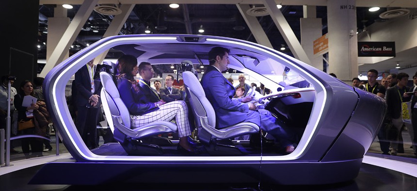 Show attendees sit in the Chrysler Portal self-driving concept car at CES International Thursday, Jan. 5, 2017, in Las Vegas.