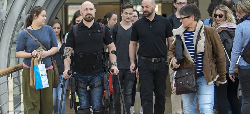 Paraplegic Dale Messenger, second from left, walks with the help of the robotic exoskeleton Ekso GT, on March 16, 2017.